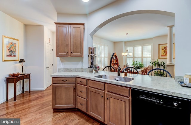 kitchen with pendant lighting, dishwasher, sink, a notable chandelier, and decorative columns