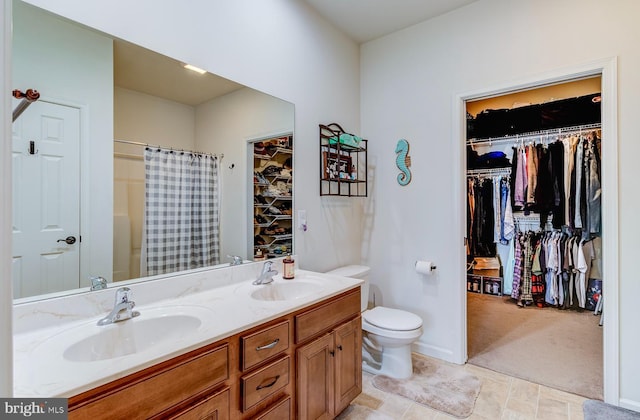 bathroom with toilet, a shower with shower curtain, and vanity