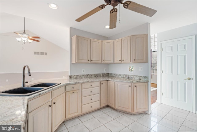 kitchen featuring vaulted ceiling, light tile patterned flooring, light brown cabinets, and sink