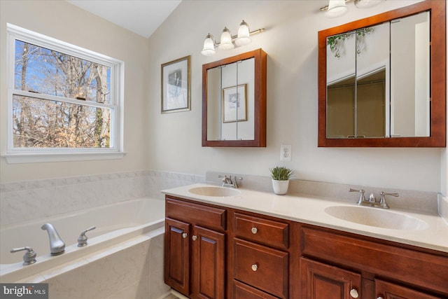 bathroom featuring tiled tub and vanity