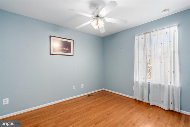 empty room with ceiling fan and light hardwood / wood-style flooring