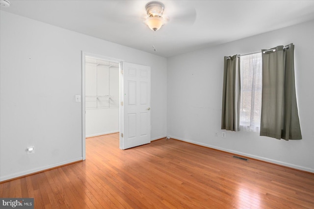 unfurnished bedroom with ceiling fan, a closet, and light hardwood / wood-style flooring