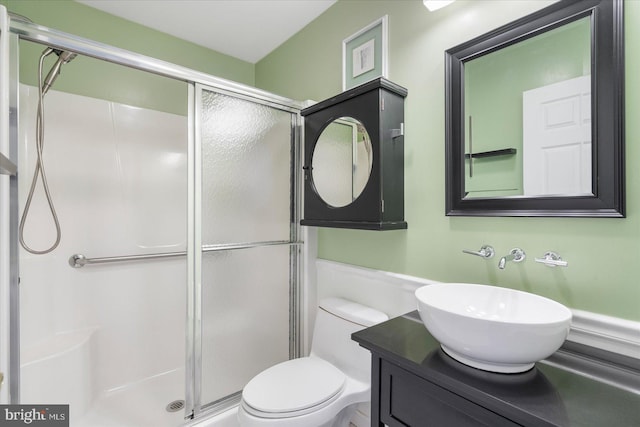 bathroom with toilet, an enclosed shower, and vanity