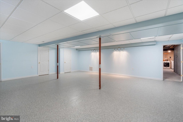 basement with a paneled ceiling and washer / clothes dryer