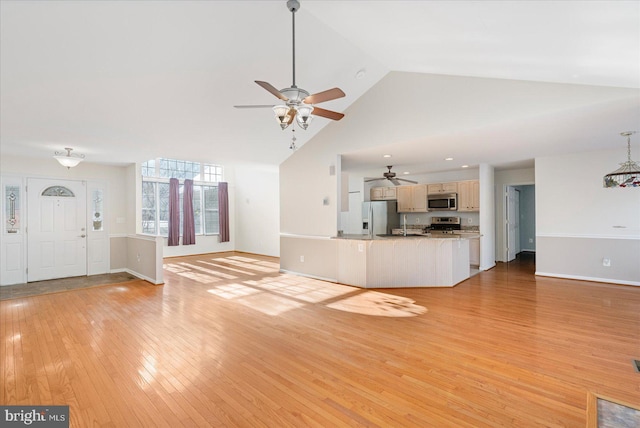 unfurnished living room with high vaulted ceiling, ceiling fan, and light hardwood / wood-style flooring