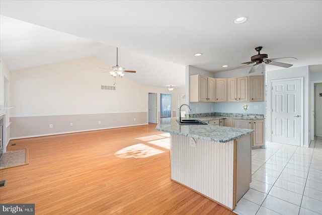 kitchen featuring sink, ceiling fan, vaulted ceiling, and kitchen peninsula