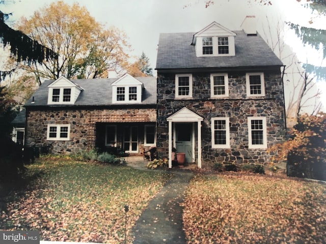 cape cod home featuring a front yard