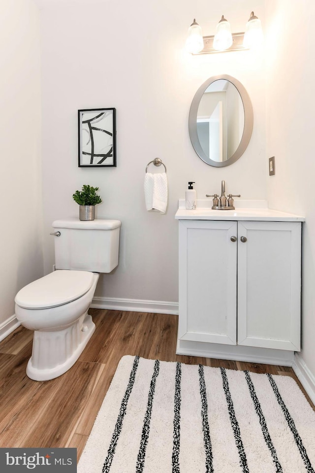 bathroom featuring toilet, vanity, and wood-type flooring