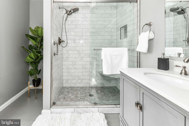 bathroom with tile patterned floors, an enclosed shower, and vanity