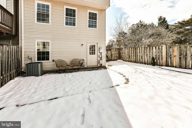 snow covered house with central AC unit