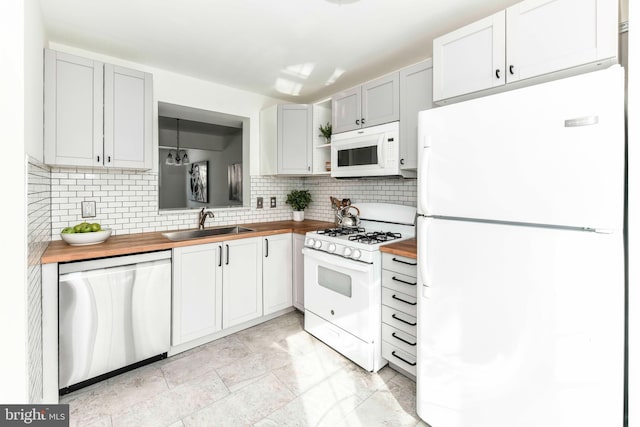 kitchen featuring white appliances, wood counters, sink, white cabinetry, and backsplash