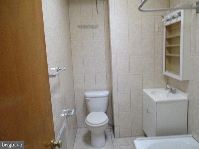 bathroom featuring tile patterned floors, vanity, a shower, tile walls, and toilet