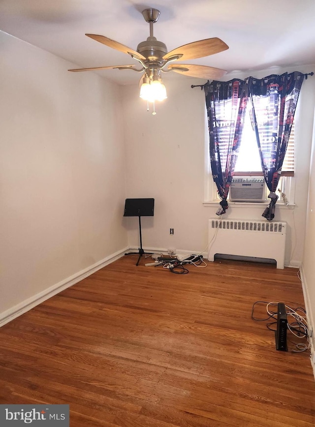 interior space featuring radiator, cooling unit, ceiling fan, and hardwood / wood-style flooring