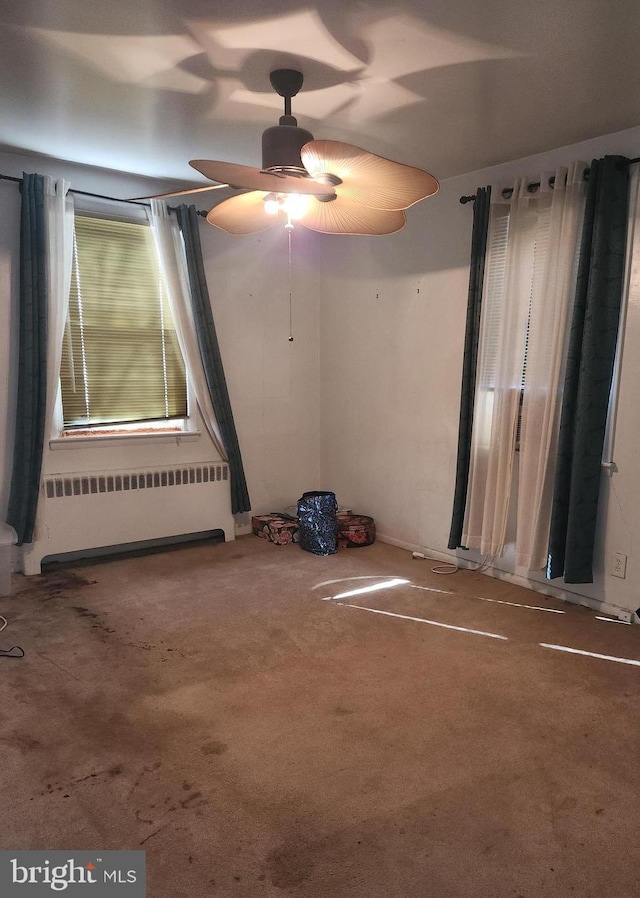 unfurnished room with radiator and carpet flooring