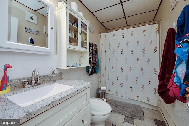 full bathroom featuring toilet, a paneled ceiling, decorative backsplash, vanity, and shower / tub combo