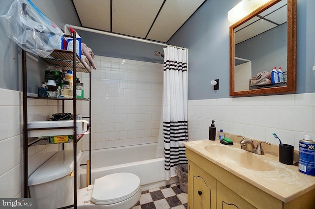 full bathroom with vanity, toilet, tile walls, and shower / tub combo