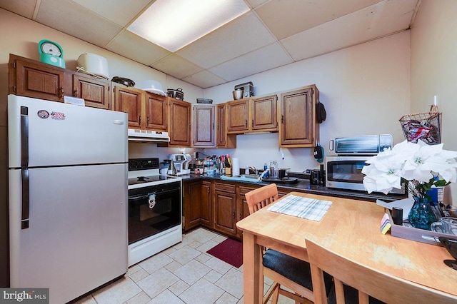 kitchen featuring a paneled ceiling, refrigerator, electric range oven, and sink