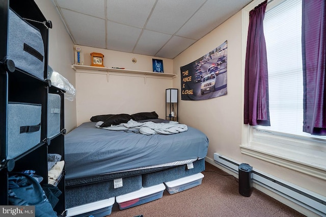 bedroom featuring carpet flooring, a baseboard radiator, and a drop ceiling