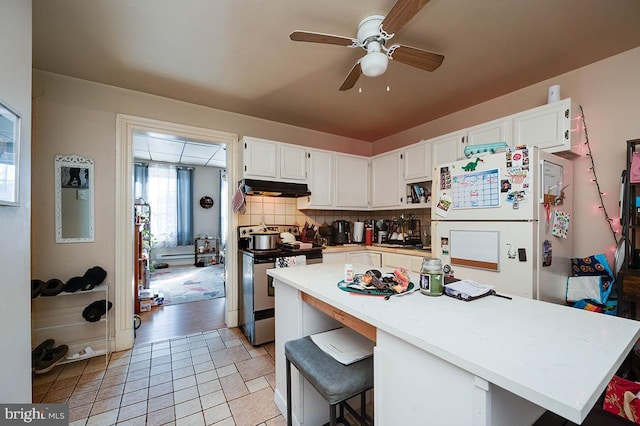 kitchen featuring stainless steel range with electric stovetop, ceiling fan, tasteful backsplash, white fridge, and white cabinetry