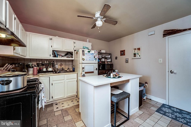 kitchen featuring white cabinetry, a center island, white fridge, a kitchen bar, and decorative backsplash