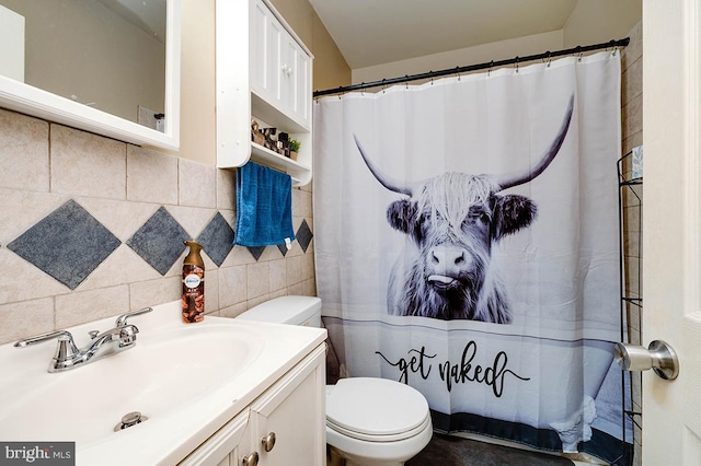 bathroom featuring vanity, backsplash, toilet, and tile walls