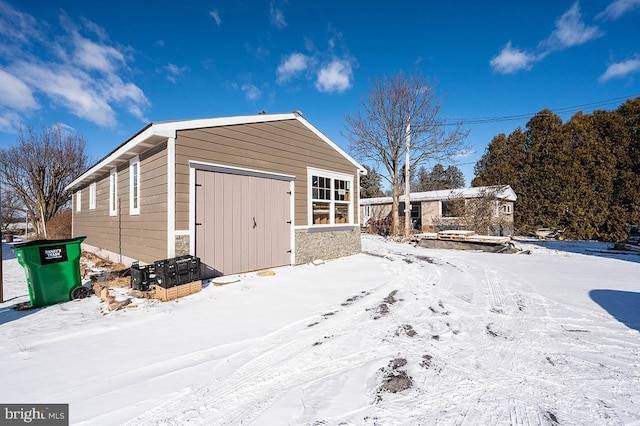 snow covered structure with a garage