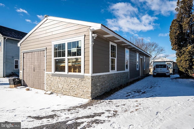 view of snow covered exterior featuring a garage