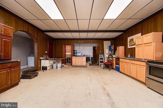 kitchen with stainless steel range with electric stovetop and washer / dryer