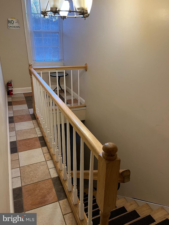 staircase with a chandelier