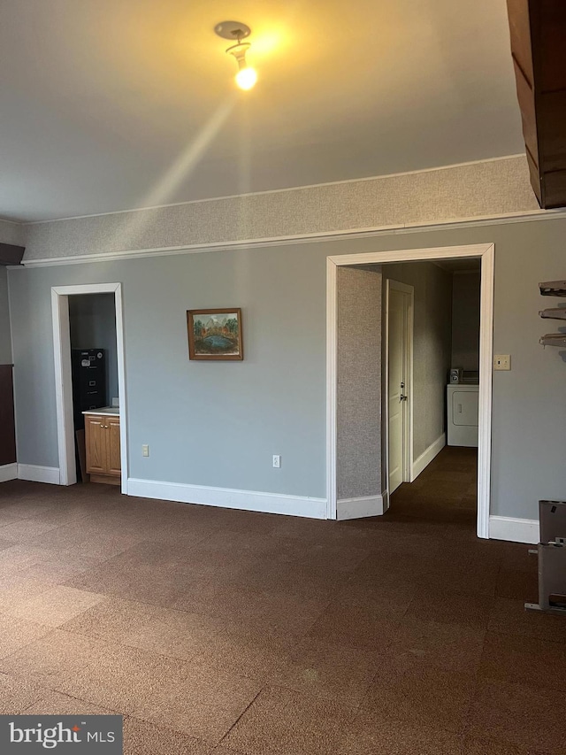 unfurnished living room with dark colored carpet and independent washer and dryer