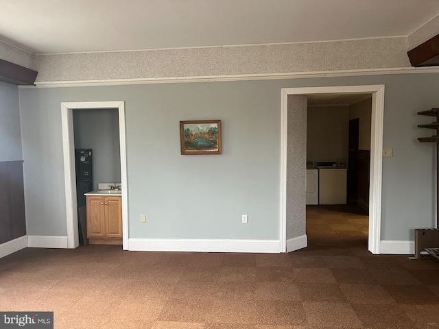 unfurnished room featuring sink, ornamental molding, and washing machine and clothes dryer