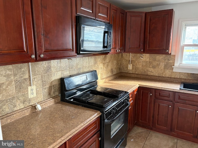 kitchen with light tile patterned floors, black appliances, and decorative backsplash