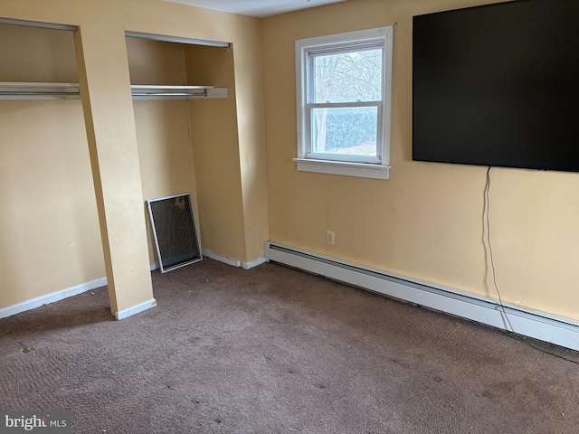 unfurnished bedroom featuring two closets, baseboard heating, and carpet floors