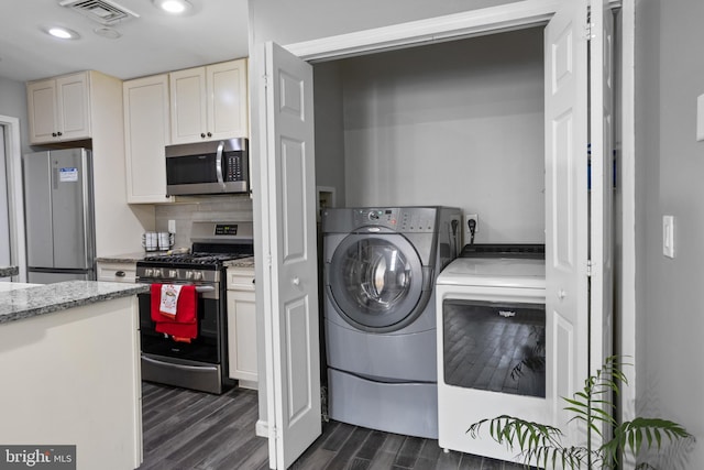 laundry area featuring dark hardwood / wood-style floors and washer and dryer