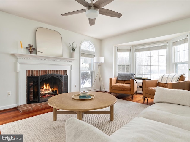 living room with wood-type flooring, a fireplace, and ceiling fan