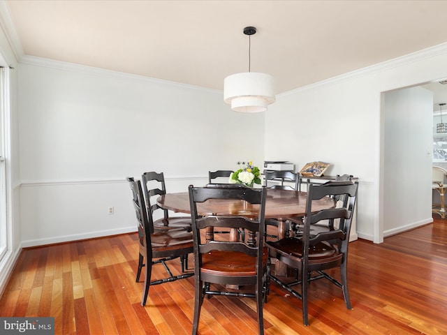 dining space featuring hardwood / wood-style floors and crown molding