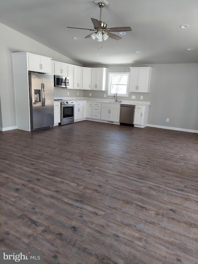 kitchen featuring vaulted ceiling, dark hardwood / wood-style floors, ceiling fan, appliances with stainless steel finishes, and white cabinetry