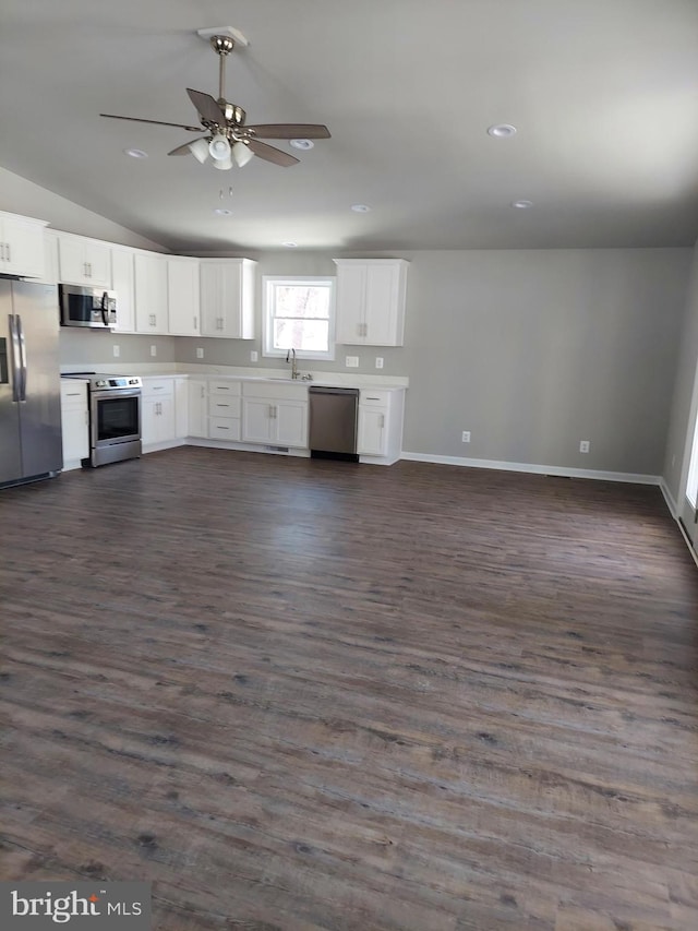 kitchen with dark hardwood / wood-style flooring, white cabinets, stainless steel appliances, and lofted ceiling