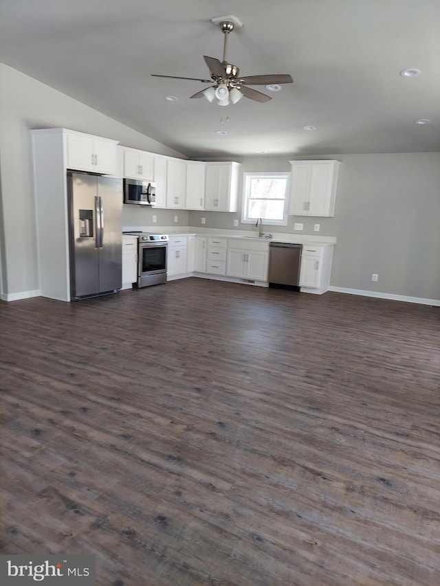 kitchen with lofted ceiling, dark hardwood / wood-style floors, white cabinetry, and stainless steel appliances