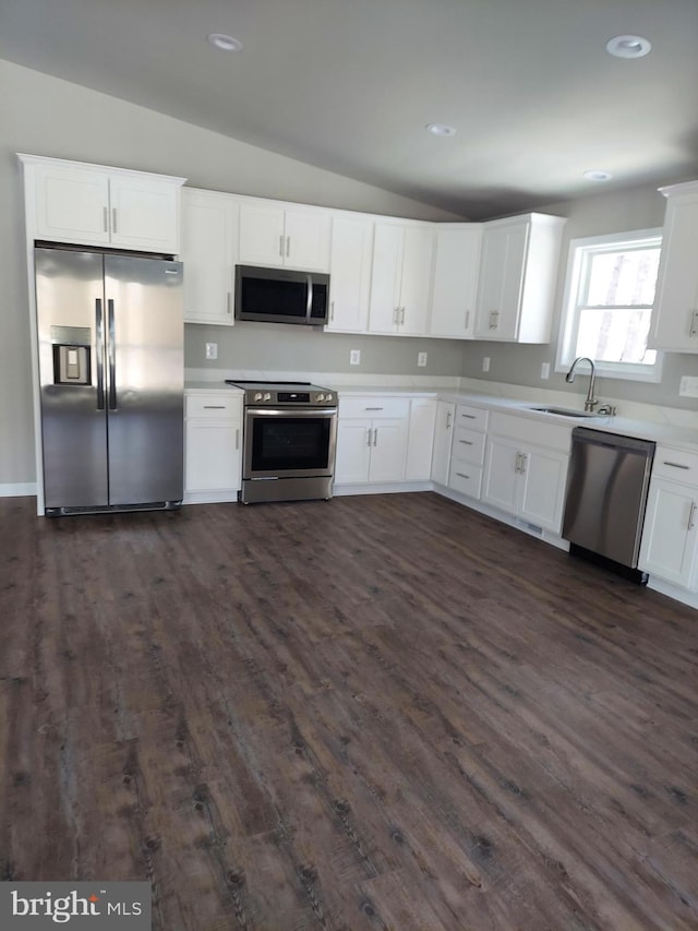 kitchen with white cabinets, lofted ceiling, sink, and appliances with stainless steel finishes