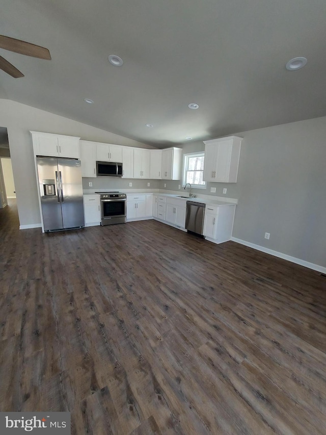 kitchen with stainless steel appliances, sink, dark hardwood / wood-style floors, white cabinetry, and lofted ceiling