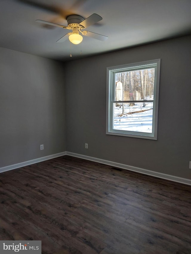 spare room with dark hardwood / wood-style floors and ceiling fan