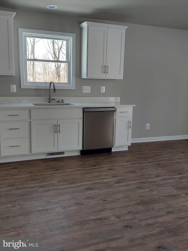 kitchen with stainless steel dishwasher, dark hardwood / wood-style floors, white cabinetry, and sink