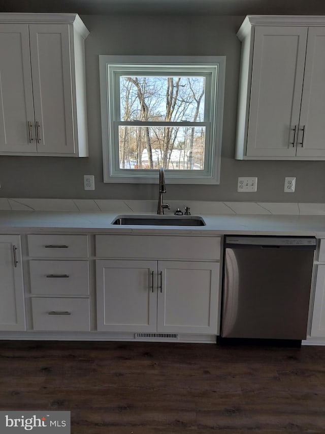 kitchen with white cabinetry, dishwasher, light stone countertops, dark wood-type flooring, and sink