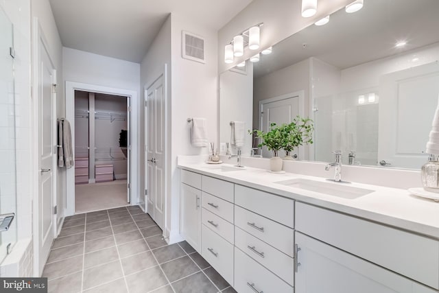 bathroom featuring tile patterned flooring, vanity, and walk in shower