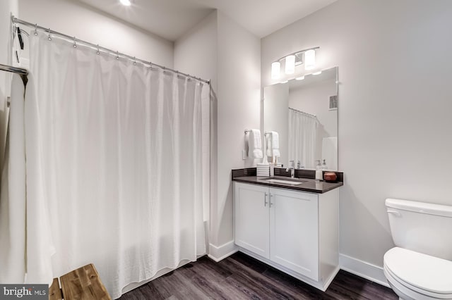 bathroom with vanity, toilet, curtained shower, and hardwood / wood-style floors