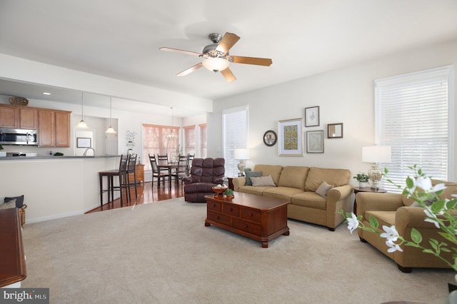 carpeted living room with ceiling fan