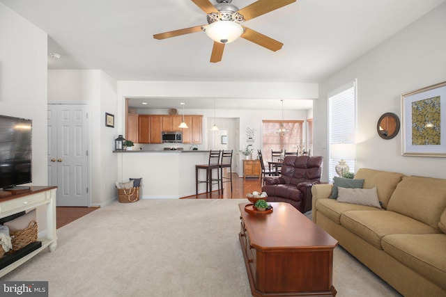 carpeted living room with ceiling fan