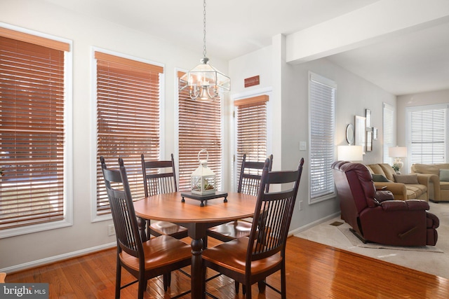 dining space with hardwood / wood-style flooring and a chandelier