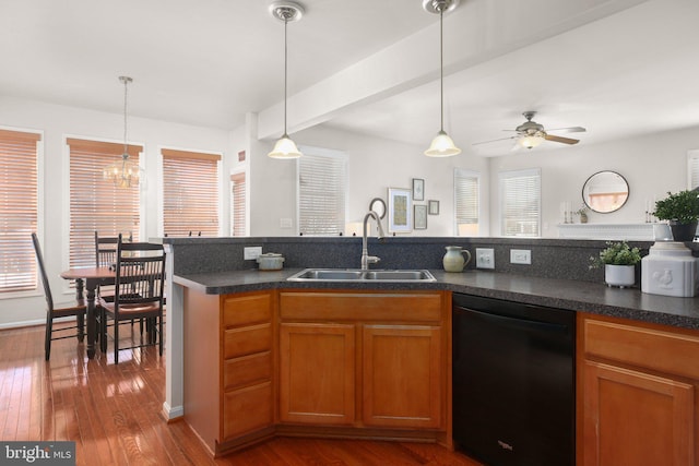 kitchen featuring sink, beamed ceiling, hanging light fixtures, dishwasher, and hardwood / wood-style flooring